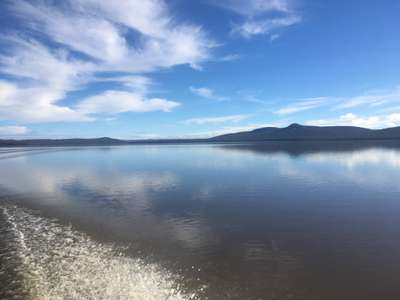 A scenic shot of Lake Sorell in winter 2018 with the sun reflecting of a calm lake.