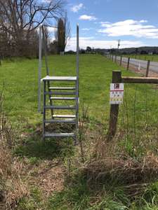 A photo of a metal stile over a fence that enables anglers access to the Mersey River across Calthorpe Farm, Latrobe.
